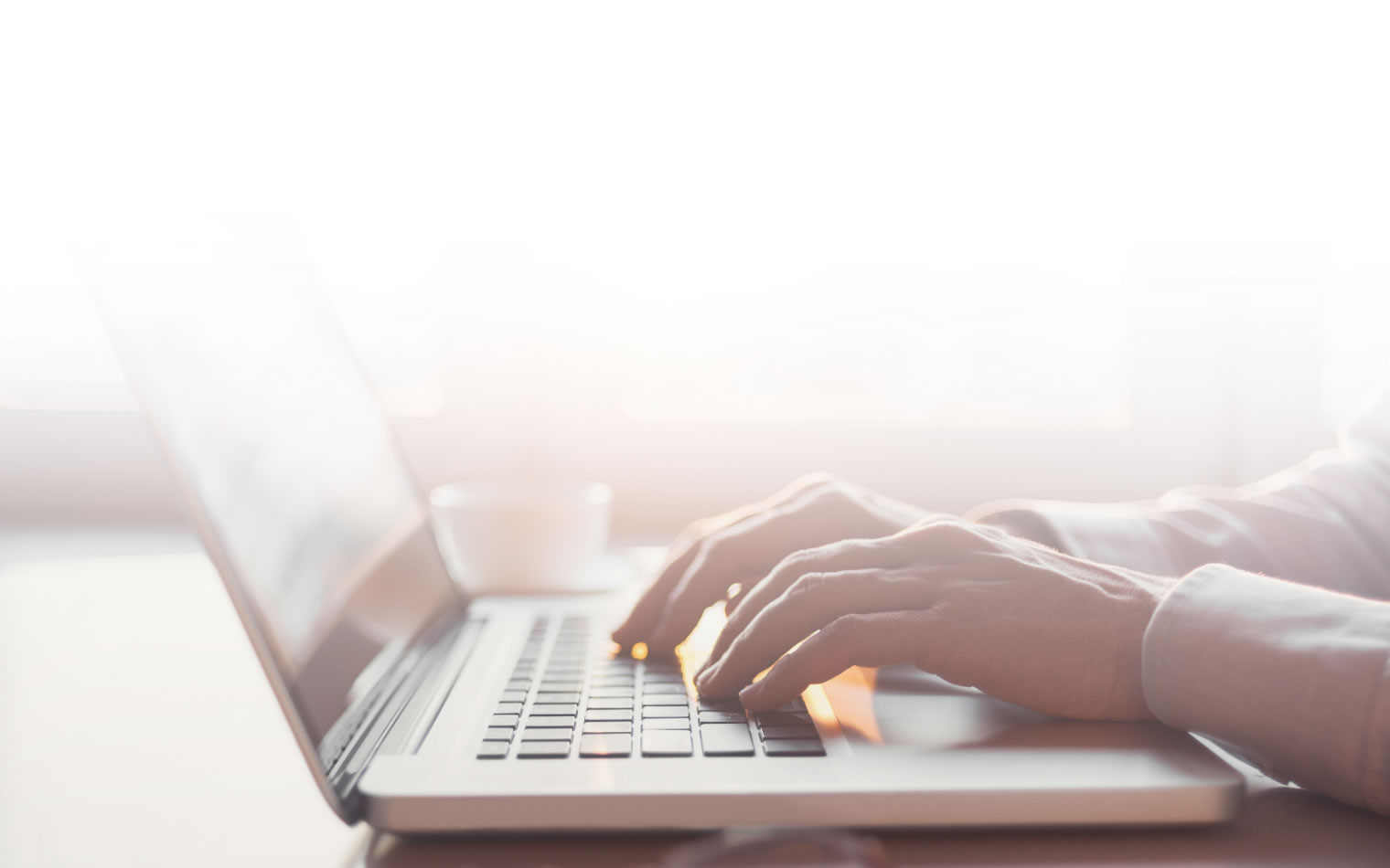 Hands typing on a laptop keyboard